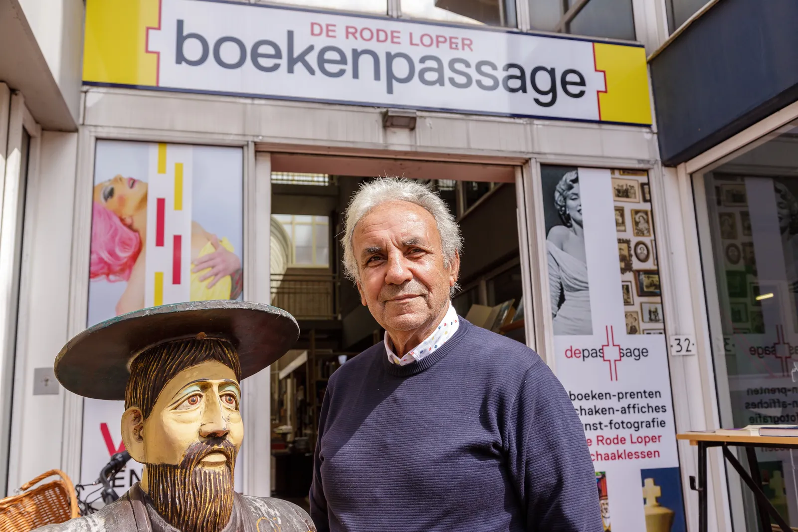 Voor de ingang van boekenpassage De Rode Loper aan de Sint Jacobsstraat 32, onder het gele uithangbord